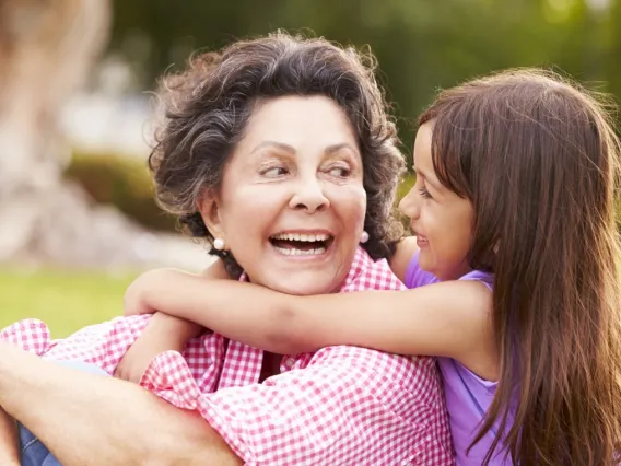 Hispanic grandmother and granddaughter hugging