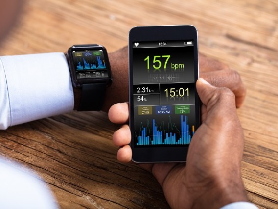Man With Smartwatch And Cellphone Monitoring Heart Rate