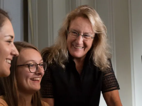 News - Barnes - Brain Research for the Ages - blonde female student, brunette female student with glasses, Carol Barnes smiling in front of computers at U of A