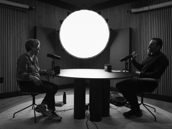 Black & white photo of U of A faculty member Mary-Frances O'Connor across the table from host Ian Mackey during Huberman Lab podcast recording