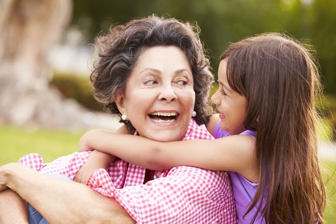 Hispanic grandmother and granddaughter hugging