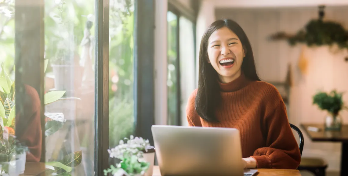 student smiling with laptop