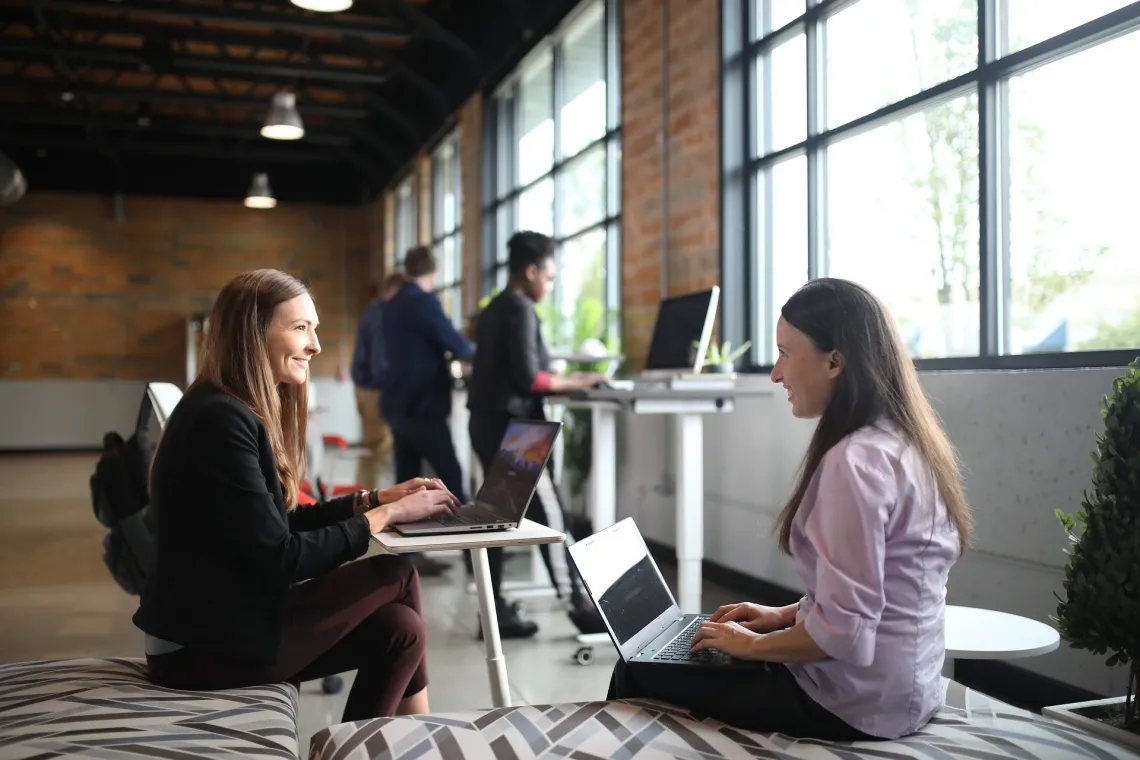 two women on laptops conversing