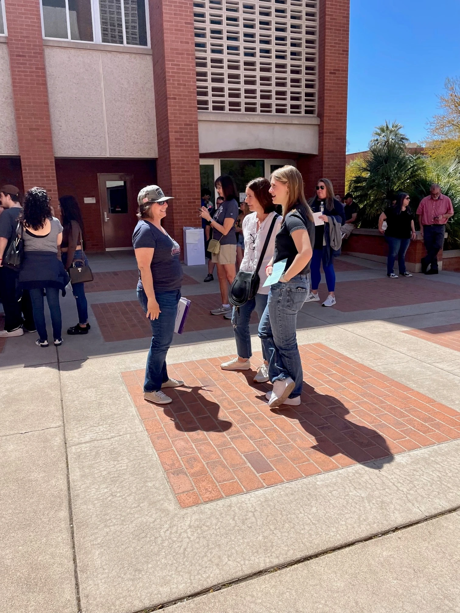Faculty talking to students in courtyard