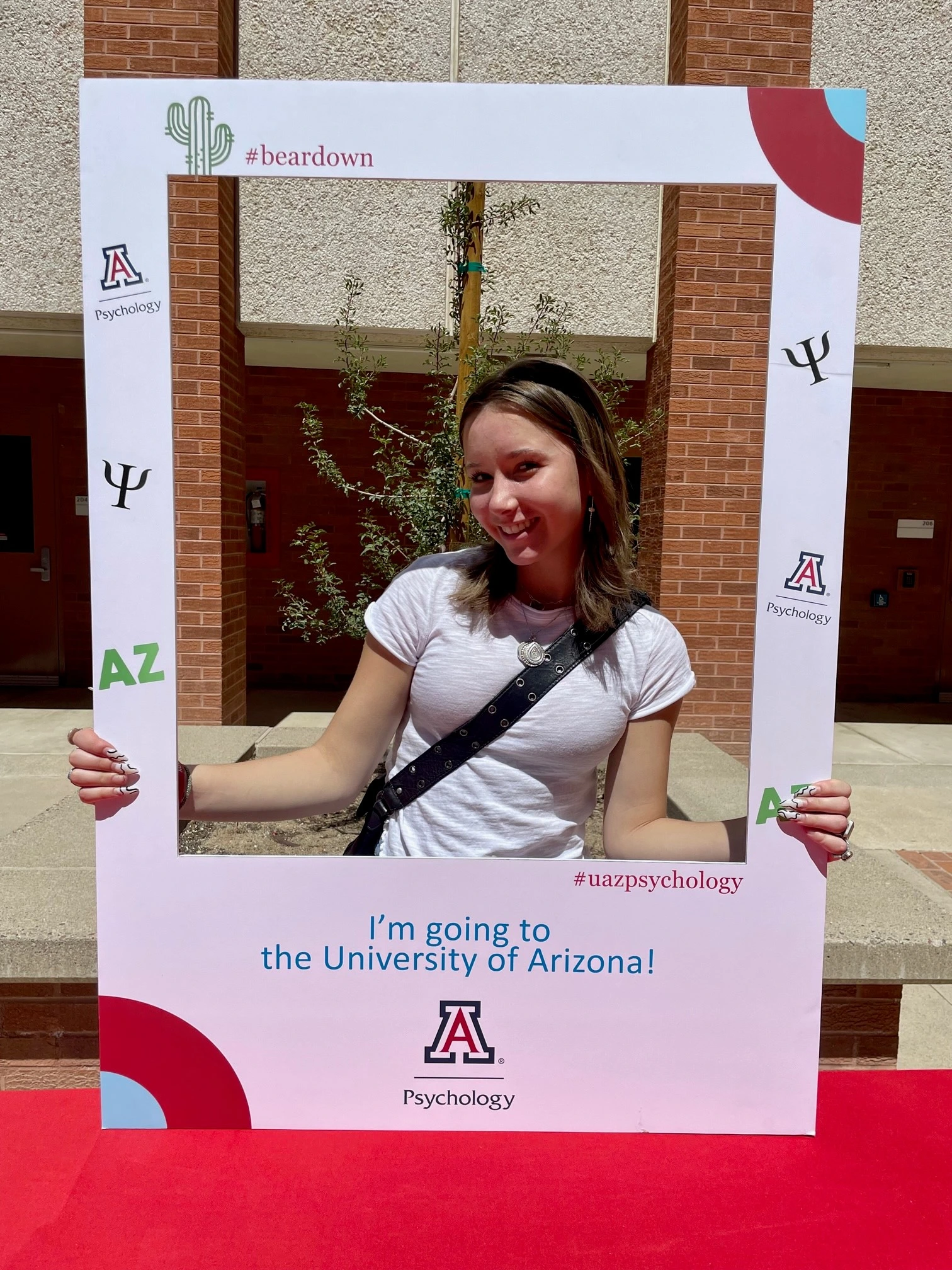 student with selfie frame sign