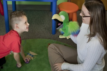 Researcher leading child cognition study with toddler