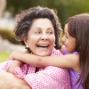 Hispanic grandmother and granddaughter hugging